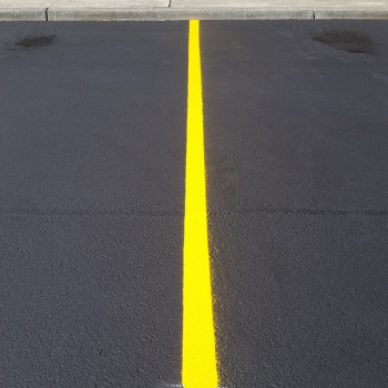 A yellow line marking on the parking lot grounds