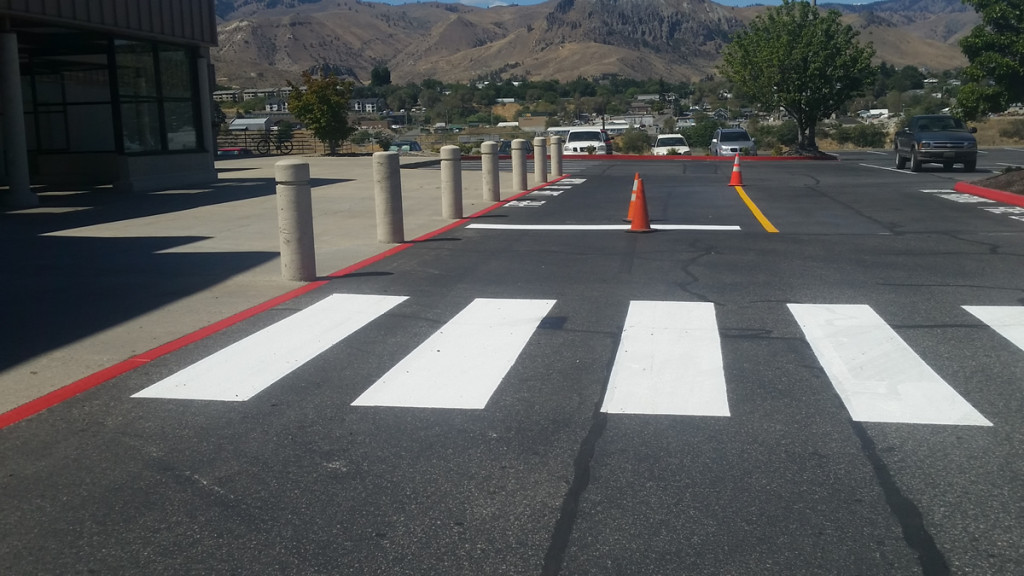 A street with white lines and orange cones.