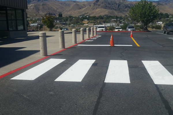 A street with white lines and orange cones.