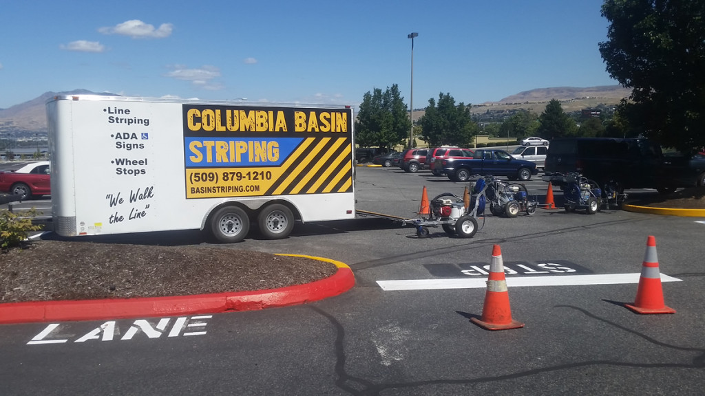 A white truck parked in the middle of a parking lot.