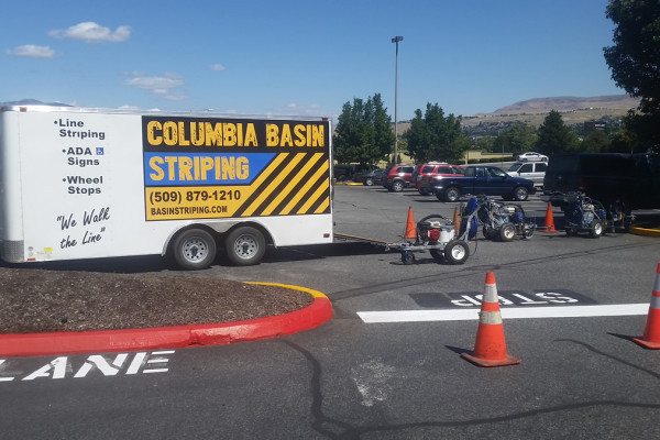 A white truck parked in the middle of a parking lot.