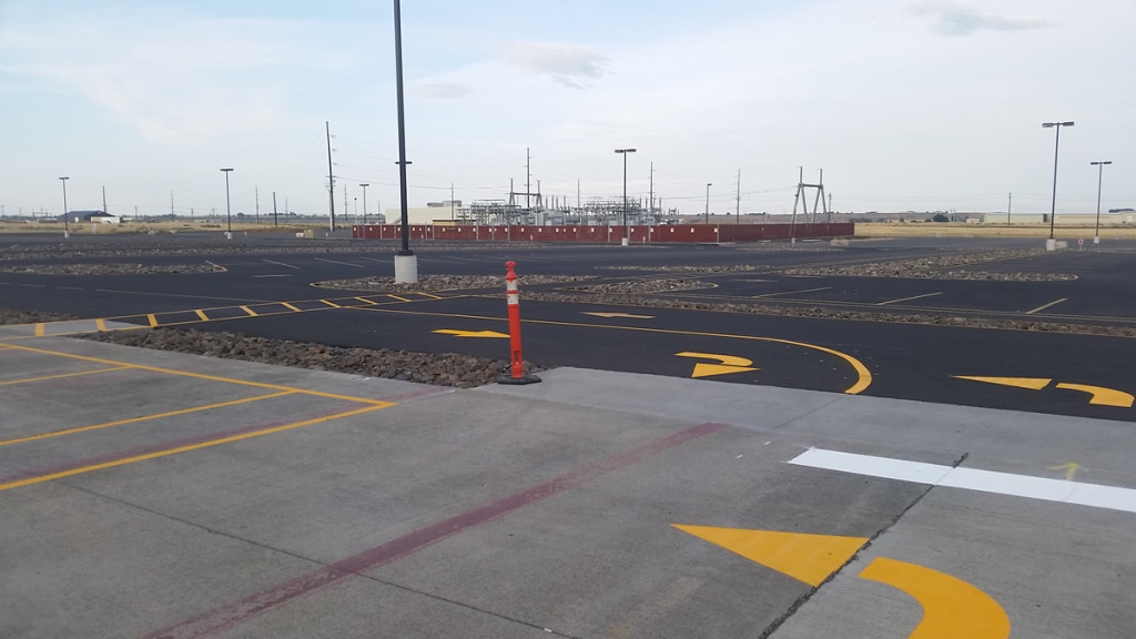 A parking lot with yellow lines and orange cones.