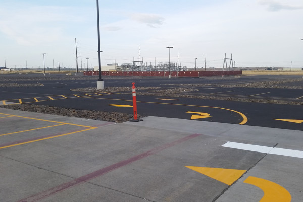 A parking lot with yellow lines and orange cones.