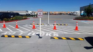 A parking lot with several cones and signs.