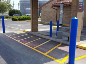 A parking lot with blue posts and yellow lines.